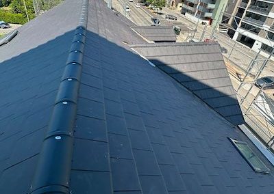 Rénovation de toiture en tuiles noires Alpha en terre cuite pour une maison à Annecy, en Haute-Savoie